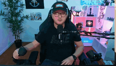 a man sitting in front of a microphone wearing a hat that says emperor on it