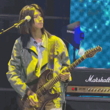 a woman is playing a guitar in front of a marshall amp