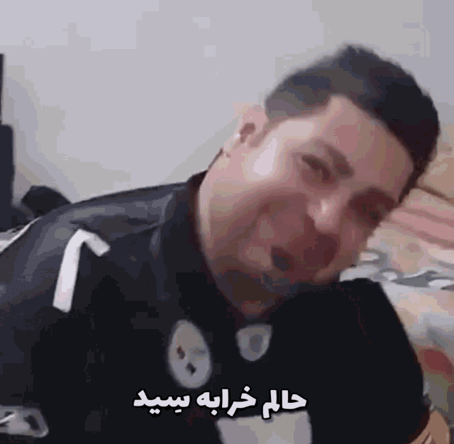 a man in a pittsburgh steelers jersey is laying on a bed and making a funny face .