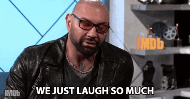 a bald man wearing glasses and a leather jacket is saying we just laugh so much
