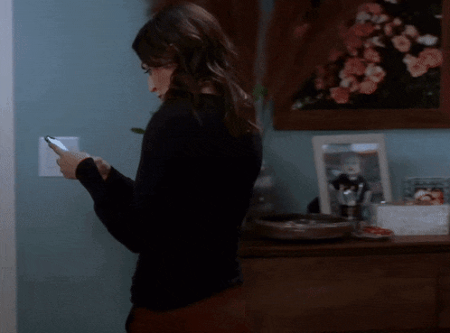 a woman is looking at her phone in a room