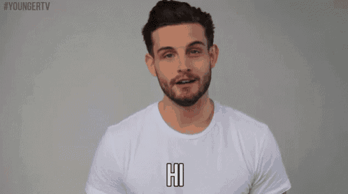 a man with a beard wearing a white t-shirt that says hi