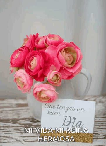 a bouquet of pink flowers in a white vase next to a card that says " que tengas un buen dia "