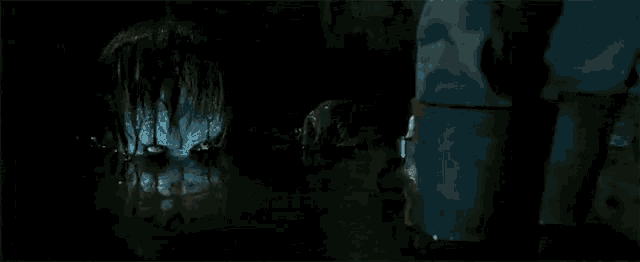 a close up of a clown 's face in a dark room in a movie .