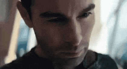 a close up of a man 's face with his eyes closed and a serious look on his face .