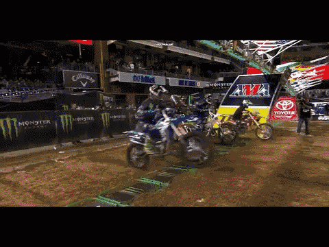 a person on a dirt bike in front of a sign that says monster energy