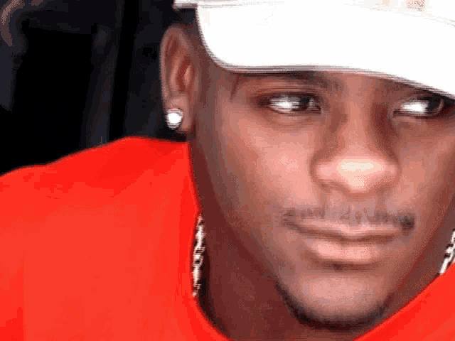 a close up of a man wearing a hat and earrings
