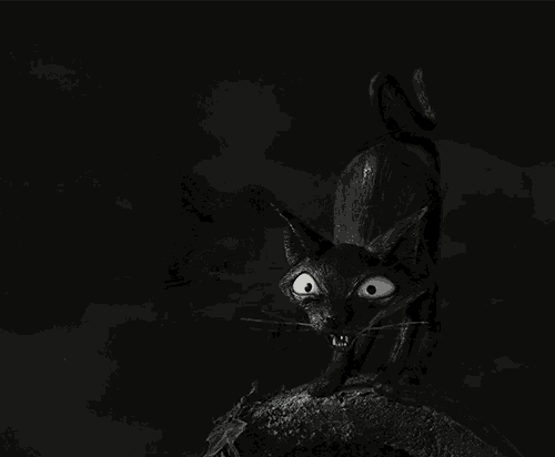 a black and white photo of a black cat with its mouth wide open
