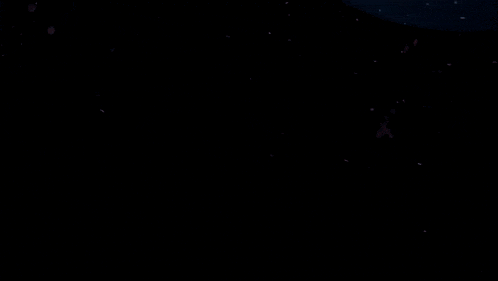 a person in a dark room with their arms outstretched reaching for something