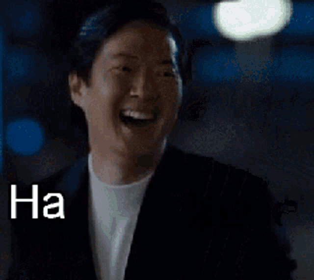 a man in a suit and white shirt is laughing with the words ha haaaa written above him