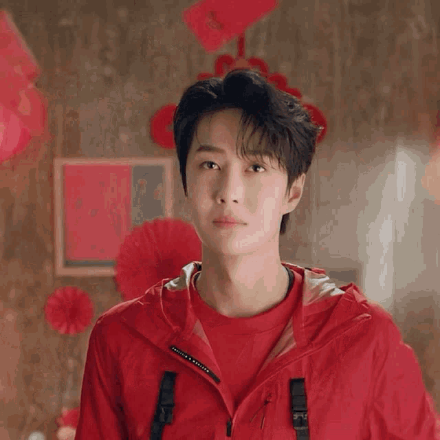 a man in a red jacket is holding a red envelope with the number 9 on it