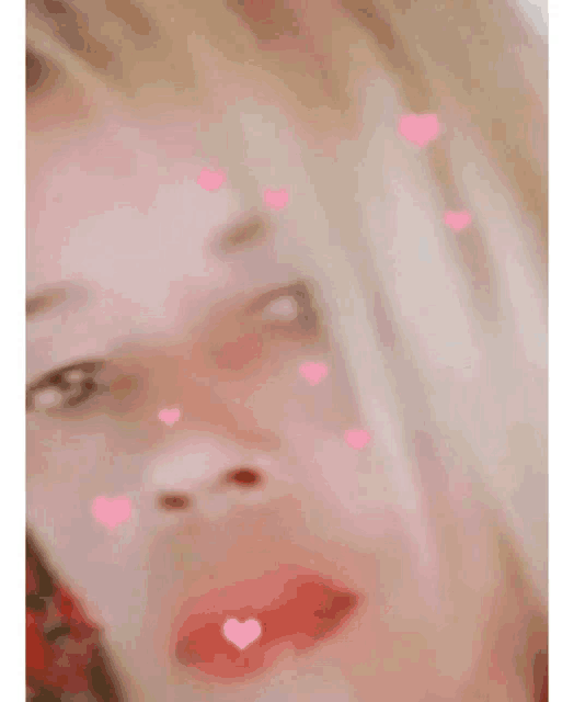 a close up of a woman with pink hearts on her face