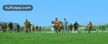 a group of men are playing soccer on a field and the website kulfyapp.com is in the corner