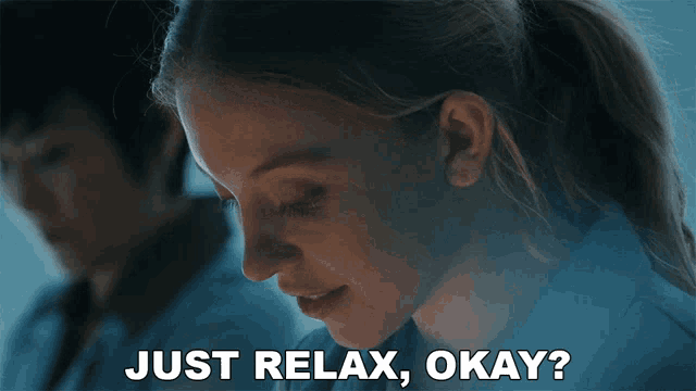 a woman is smiling with the words just relax okay written below her