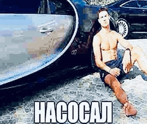 a shirtless man is sitting on the ground next to a bugatti chiron .