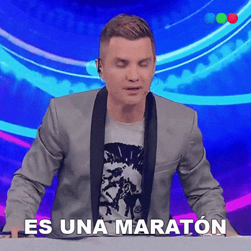 a man in a suit is sitting at a table with his eyes closed and says es una maraton
