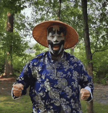 a man wearing a mask and a hat is standing in a park