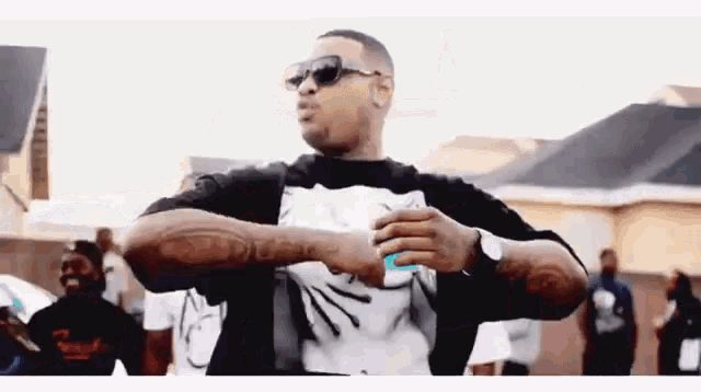 a man wearing sunglasses and a black shirt has a tattoo on his arm that says ' i love you '