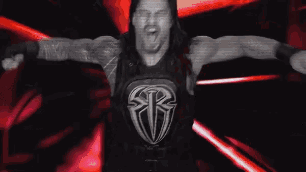 a wrestler is kneeling down in a dark room with a red and white logo in the background .