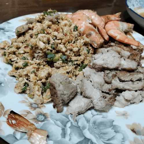 a plate of food with meat and shrimp on it