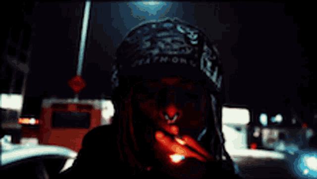 a man with dreadlocks is wearing a hat that says death on it