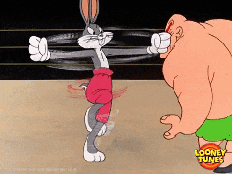 bugs bunny from looney tunes is boxing a man in a ring .