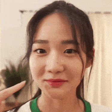a close up of a young woman making a funny face with her finger .