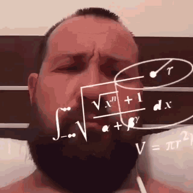 a man with a beard is laying on a bed with math equations on his face