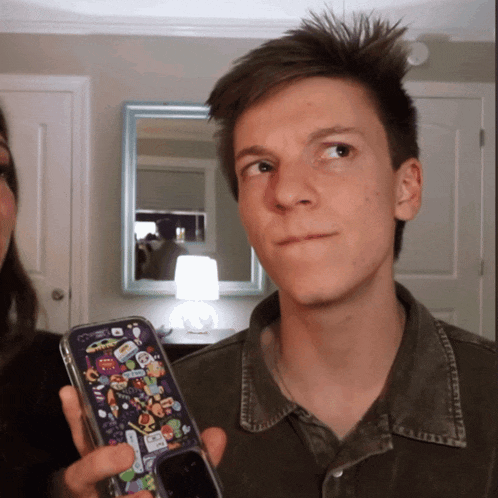 a man holding a phone with a case that says ' spongebob squarepants ' on it