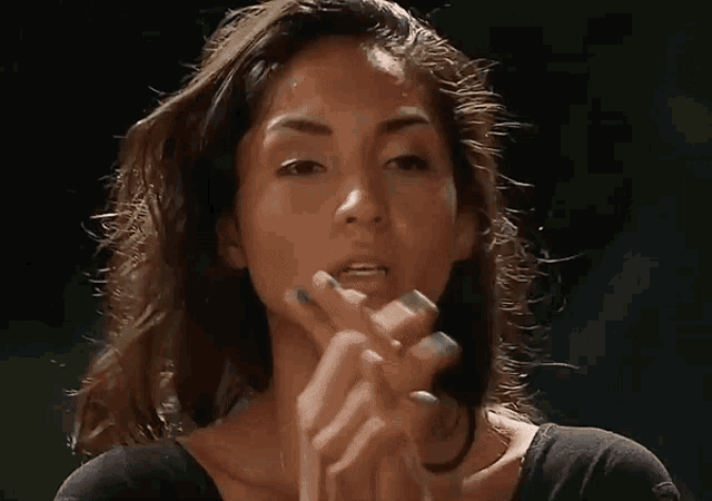 a close up of a woman applying lipstick