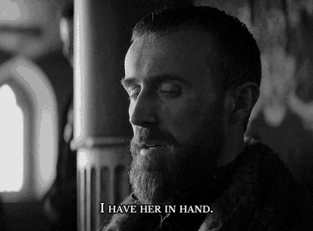 a man with a beard says " i have her in hand " in a black and white photo