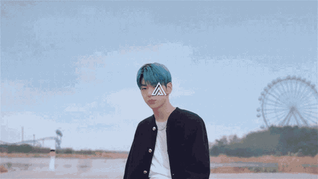 a man with blue hair is standing in front of a ferris wheel with the letter a on his face