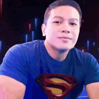 a man wearing a blue shirt with a superman logo