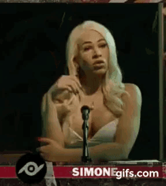 a woman is sitting in front of a microphone and talking .