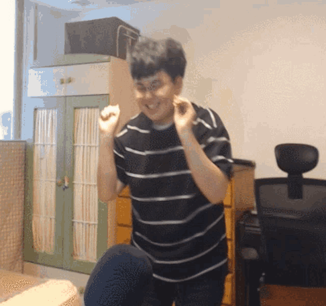 a man wearing a black and white striped shirt is dancing