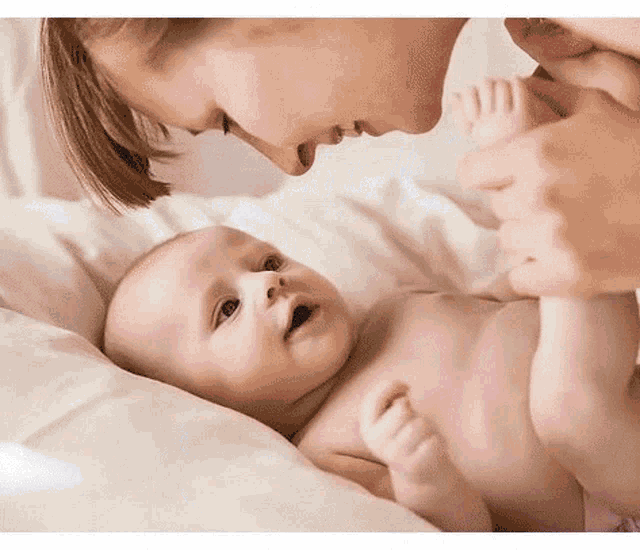 a woman is holding a baby 's foot and looking at it .