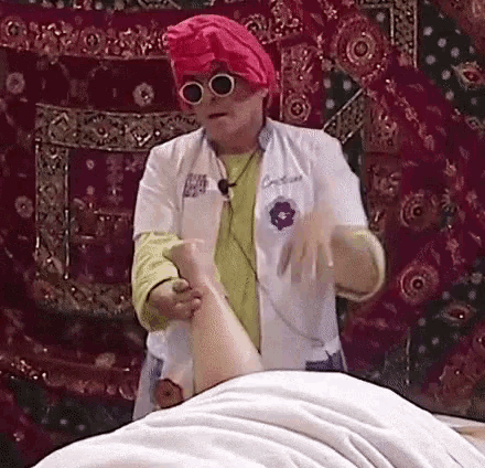 a woman in a pink turban and sunglasses is giving a massage to a person .