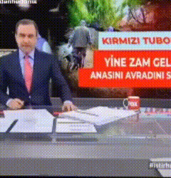 a man in a suit and tie is sitting at a desk in front of a red sign that says " kirmizi tubo "