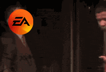 a man in a red shirt is standing next to a man in a suit with a ea logo on his head