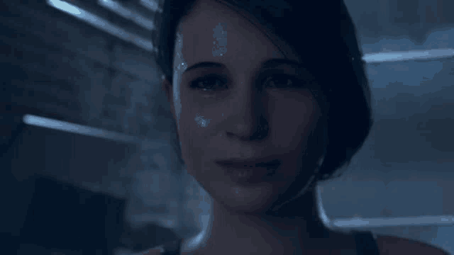 a close up of a woman 's face with tears running down her face in a dark room .