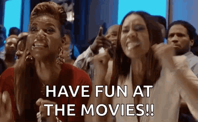 a group of people are sitting in a theater watching a movie and one of them is screaming .
