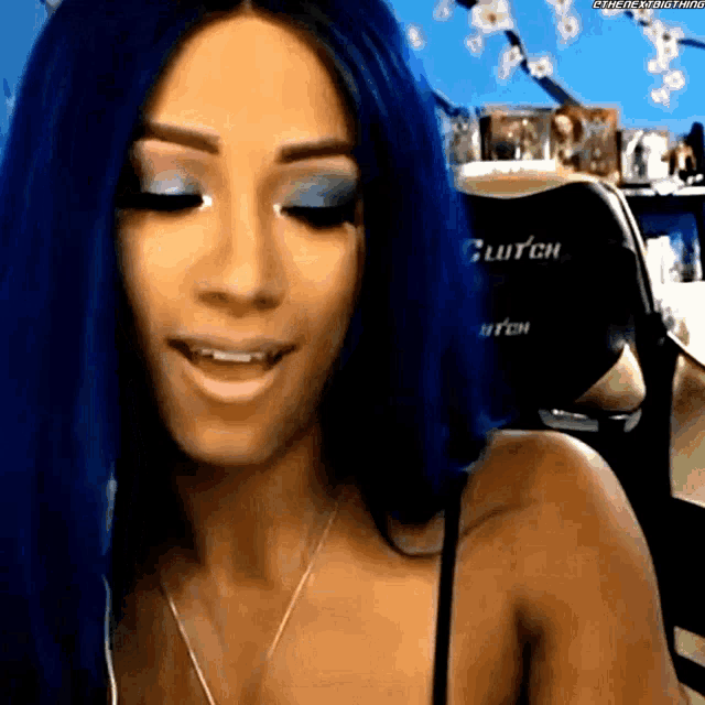 a woman with blue hair is wearing a black bra and a necklace .