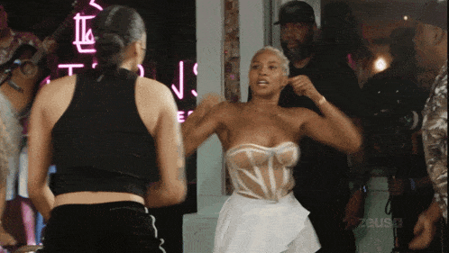 a woman in a white corset is standing in front of a neon sign that says zeus