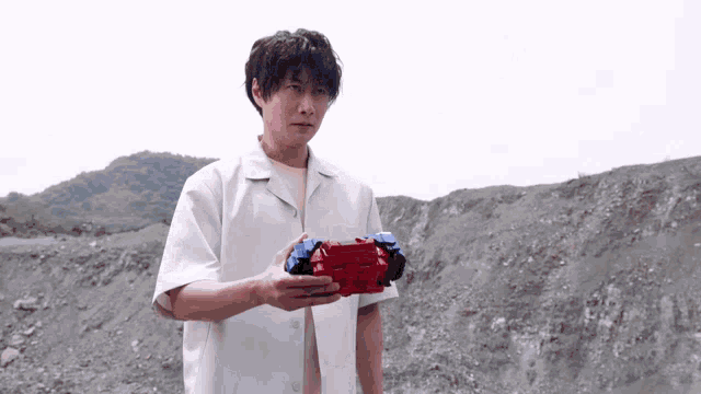 a man in a white shirt holds a red and blue object