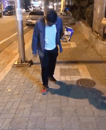 a man is walking down a sidewalk holding a bag of chips .