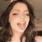 a woman is sticking her tongue out and smiling .