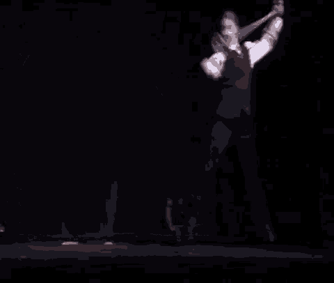 a man in a suit is dancing on a stage with a woman holding a piece of paper