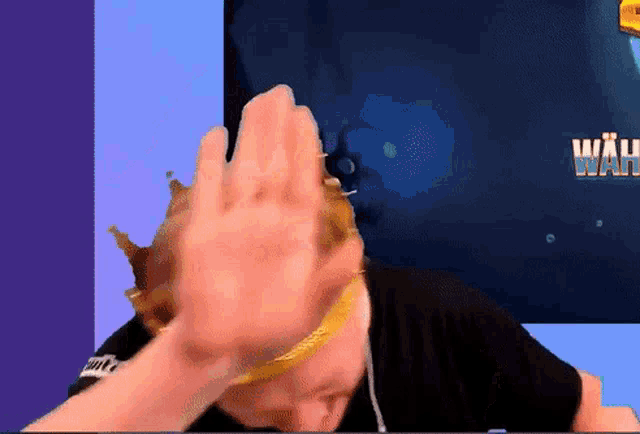 a person with a crown on their head in front of a screen with wah written on it