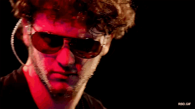a close up of a man wearing sunglasses and ear plugs