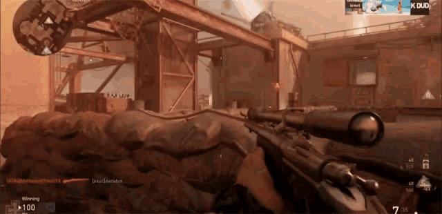 a video game screen shows a person holding a sniper rifle in front of a building that says x duo on it